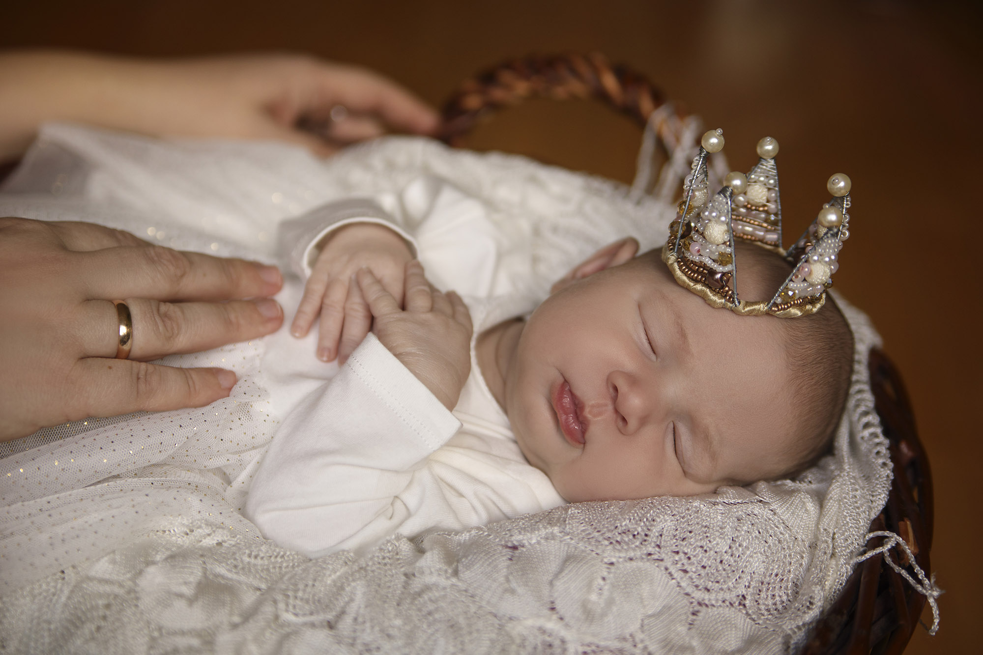 Sleeping infant in a basket with a crown