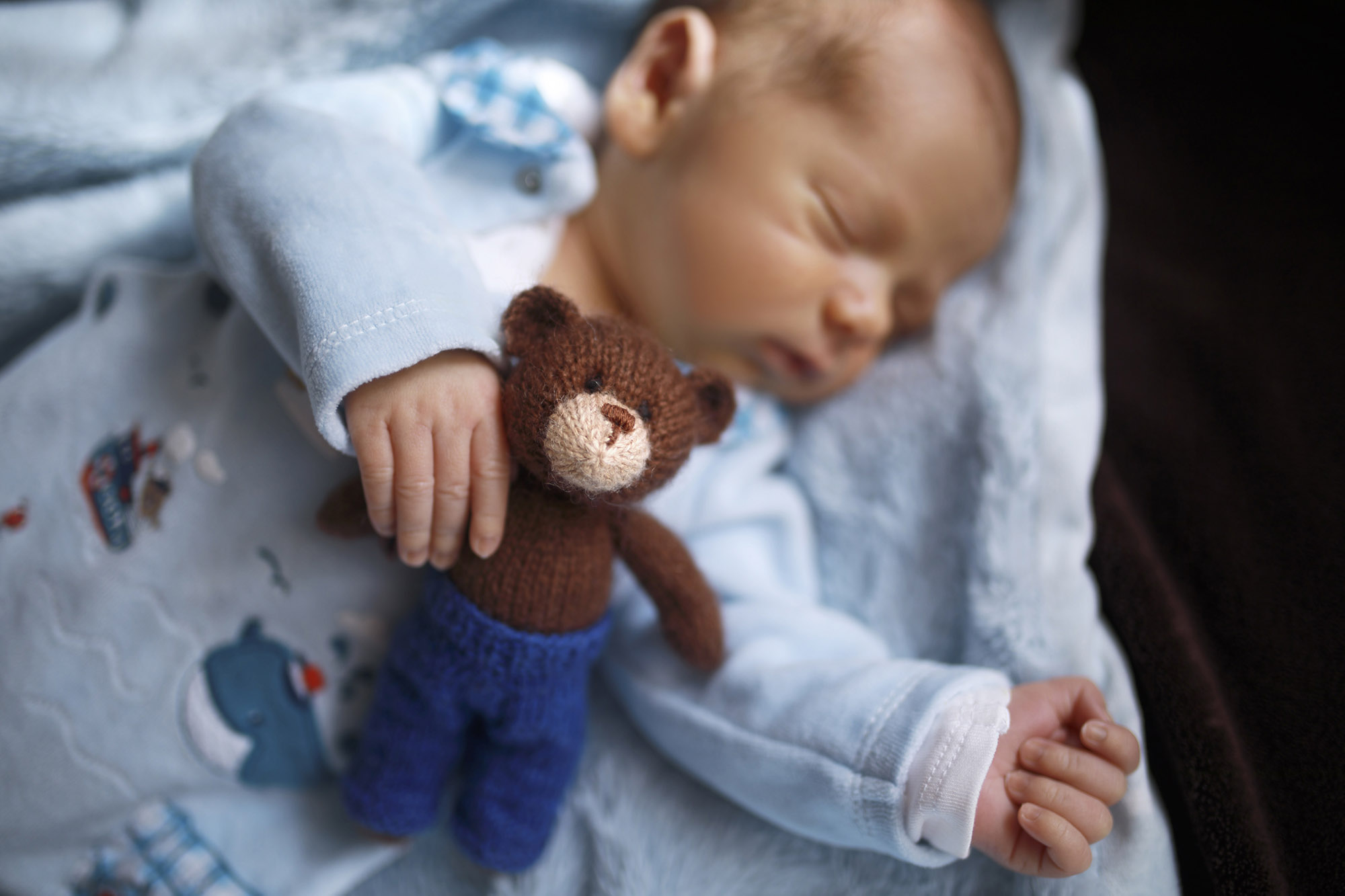 Sleeping infant with knitted toy