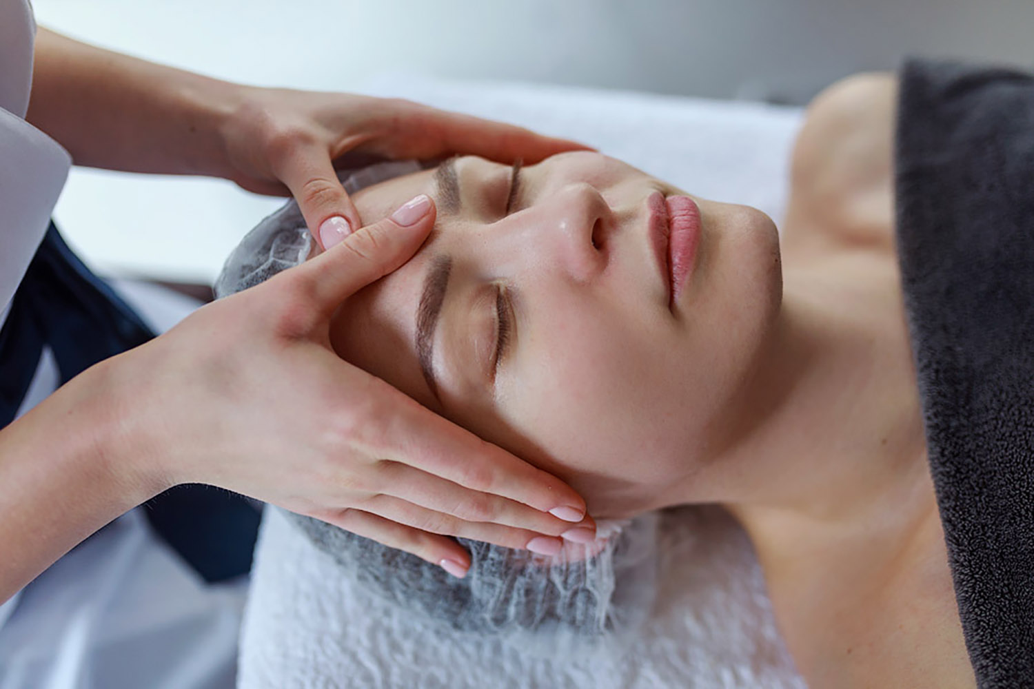 Woman is giving a face massage to a woman