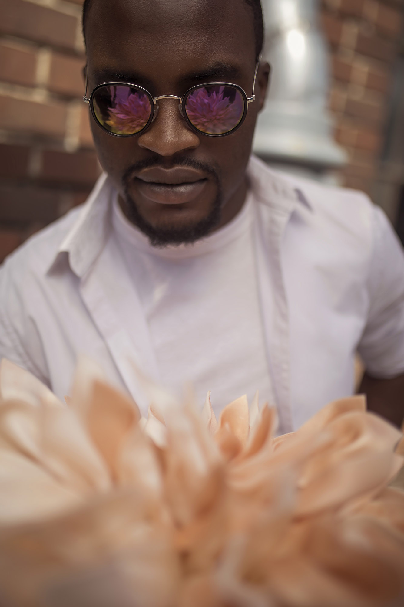 Black man wearing sunglasses with a flower