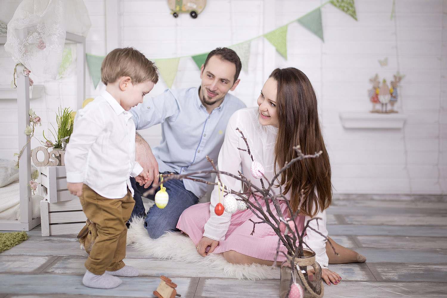 Mother, dad and son are playing on the bright background