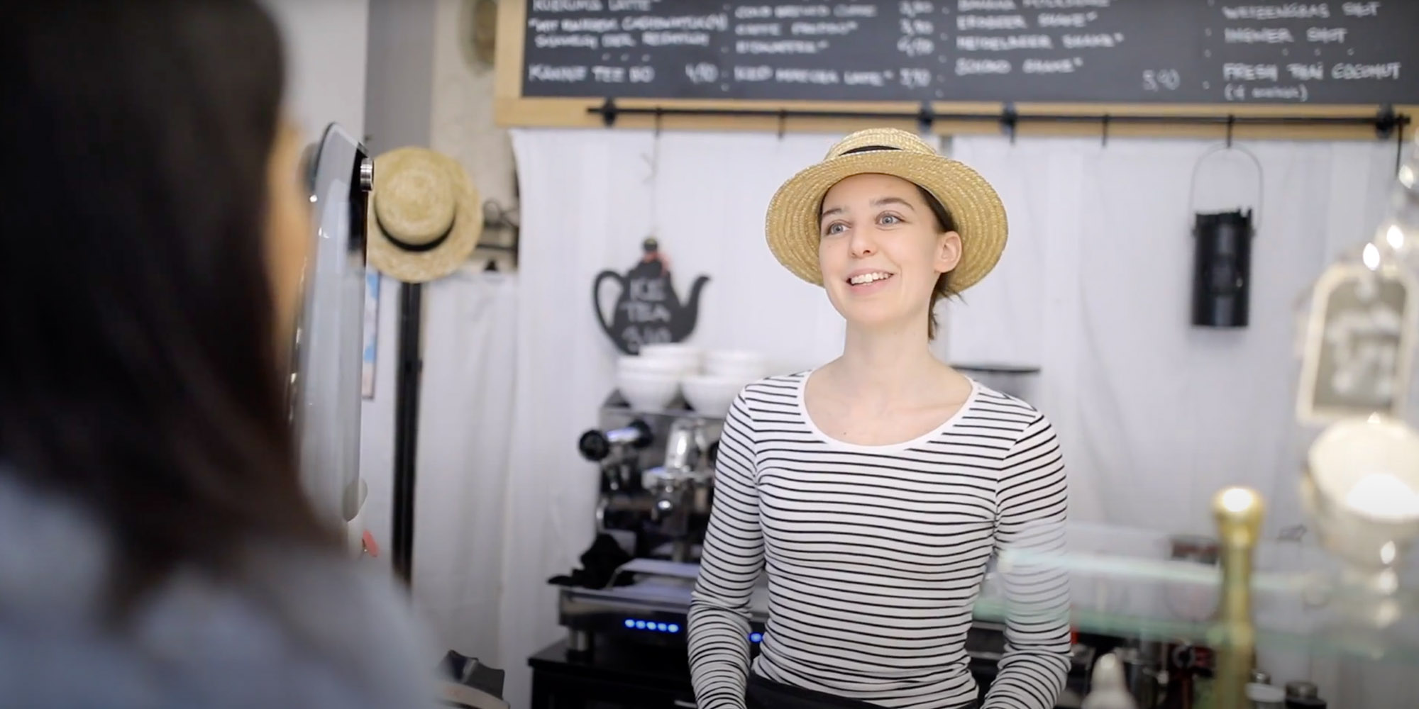 Smiling woman behind the counter in a caffe