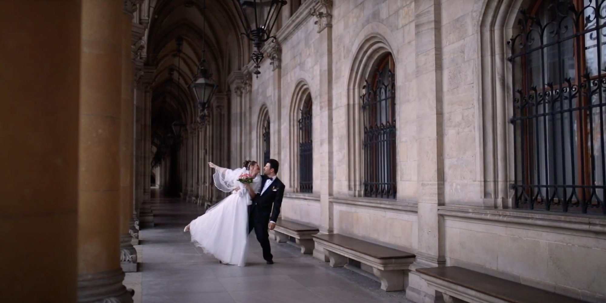 Married couple is dancing in medieval colonnade